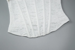 Dettaglio del pizzo floreale e delle stecche di supporto sul top a corsetto bianco