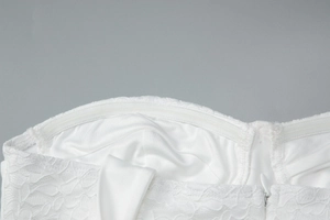 Dettaglio top in pizzo bianco con striscia interna in silicone antiscivolo e zip invisibile