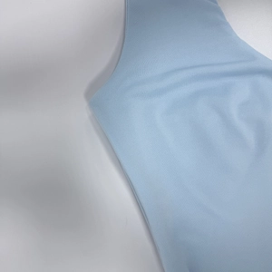 Dettaglio del tessuto a maglia celeste con trama fine e cucitura della spalla senza maniche