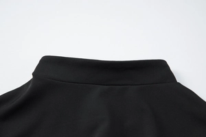 Détail du col montant et des coutures de cette robe moulante noire élégante
