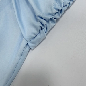 Macro del tessuto a costine azzurro con dettagli arricciati sull'abito aderente chic