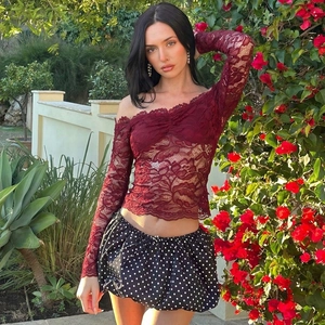 Set donna con top in pizzo bordeaux con spalle scoperte e gonna a pois nera all'aperto