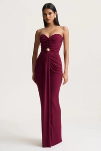 Detail of burgundy tube dress with ruched waist and decorative golden metal ring buckle