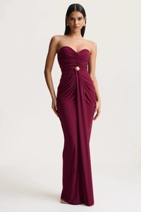 Detail of burgundy tube dress with elegant pleated fabric and golden waist ornament