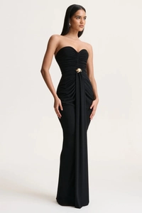 Detail of elegant black strapless gown featuring ruched waist and decorative gold buckle