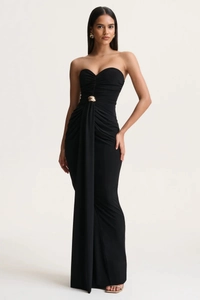 Detail of elegant black strapless dress with ruched fabric and gold metal waist ornament
