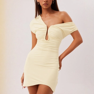 Détail de la mini-robe moulante jaune pâle avec épaule asymétrique et découpe sur le devant