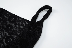 Détail de robe en dentelle noire avec mesh transparent et motifs floraux en velours