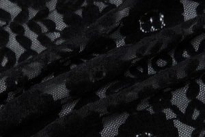 Vue macro détaillée du tissu en dentelle noire avec motifs floraux ajourés