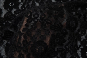 Détail du tissu en dentelle florale noire semi-transparente avec broderie florale