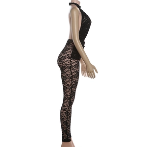 Detail of sheer black floral lace material on backless halterneck slim jumpsuit
