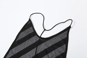 Détail macro des bretelles en maille noire et du décolleté rayé sur une robe moulante