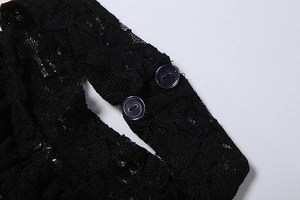 Detailed macro view of black lace fabric and dual button closure on the neck area