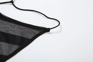 Gros plan sur le tissu en maille noire et la sangle élastique d'une robe sexy