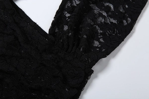 Detail of delicate black floral crochet lace and ruffled neckline on the bodysuit