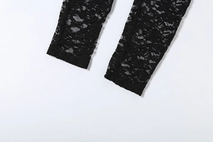 Detailed view of sheer black floral lace cuffs with intricate cut-out embroidery patterns