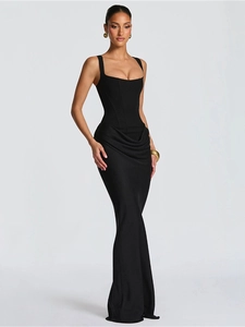 Detailed view of structured waist seams and asymmetric ruffled drapes on black evening dress