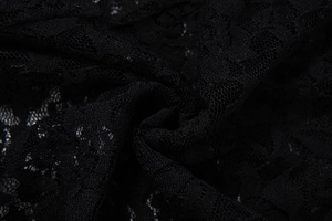 Detailed close-up showing the intricate floral lace texture and hollow design on black fabric