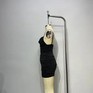 Vue détaillée de la texture froncée et de la coupe ajustée sur le côté de la mini robe noire