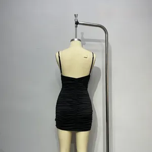 Détail de mini robe noire moulante avec design plissé et dos nu élégant