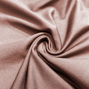 Macro shot of rose gold metallic ribbed knit fabric with soft elastic texture