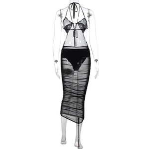 Detailed view of black mesh three-piece set with halter top and pleated skirt