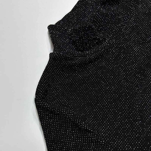 Detailed view of black mock neck jumpsuit with sparkling fabric texture and knit detail