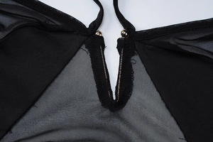 Macro detail of sexy black mesh dress featuring V-neckline with gold bead accents