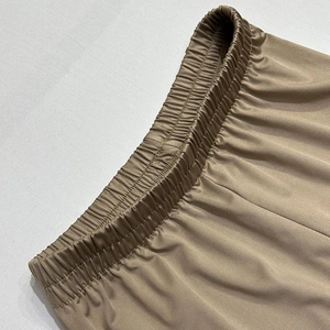 Vue détaillée de la taille élastique d'un pantalon en satin avec texture satinée bronze