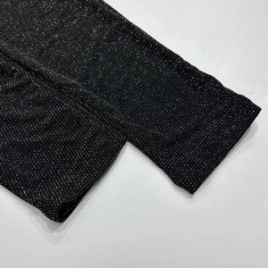 Close-up of black sparkly stretch fabric with fine silver glitters and neat stitching