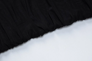 Detailed macro view of black sheer mesh fabric with intricate ruched pleated textures