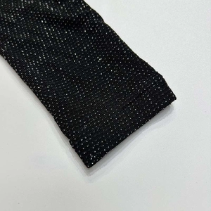 Close-up of black knit fabric with silver glitter threads showing textured details