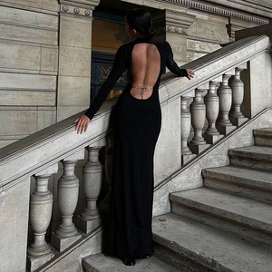 Detail of elegant backless black dress featuring an open back with silver metal chain decor