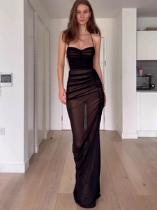 Détail d'une robe longue en maille noire avec texture froncée et fente latérale