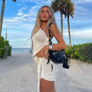 Detail of white one-shoulder knit top and ruched drawstring skirt for summer