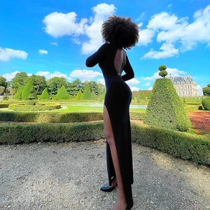 Outdoor shot of a backless halter evening dress with a high side slit in black