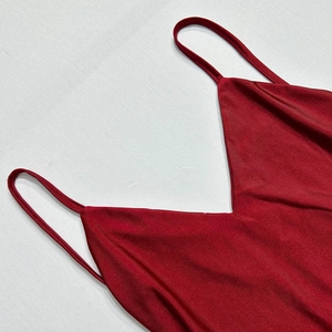Detail of red satin dress featuring a deep V-neckline and delicate spaghetti straps