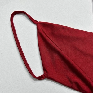 Close-up of red satin fabric texture and thin strap stitching on an elegant evening gown