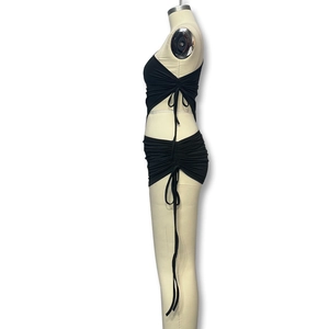 Detail view of the side ruching and long drawstring on the black mini skirt and top set