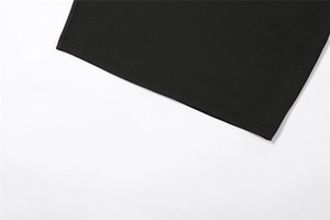 Detailed view of the double-needle stitched hem on a black knitted slim-fit dress