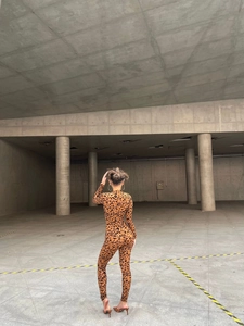 Back view of slim fit leopard print jumpsuit with long sleeves in industrial studio