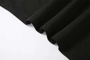 Detail view of double-needle stitching and fine knit texture on black dress hemline