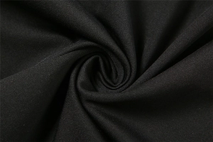 Macro shot of black knitted fabric showing fine texture and smooth drape of the dress