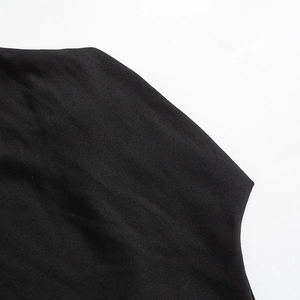 Detailed close-up showing the precise stitching and black knitted fabric of the dress shoulder