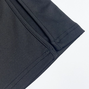 Detail shot of black knit dress showing neat stitching and split hem craftsmanship