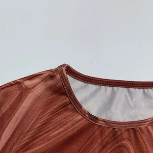 Close-up of crew neck stitching and brown marble print texture on long sleeve dress