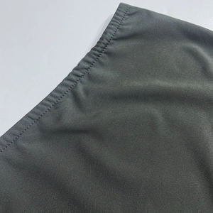 Close-up of dark grey knitted fabric showing fine texture and professional stitching detail