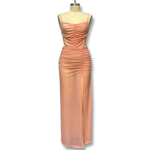 Détail de robe longue froncée rose pêche avec découpe latérale et fente haute sexy