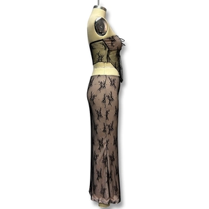Dettaglio del set a due pezzi in pizzo nero con lacci laterali e fodera beige