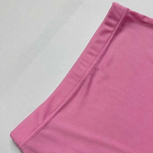 Close-up of pink vertical ribbed knit fabric texture on the waistband of the skirt